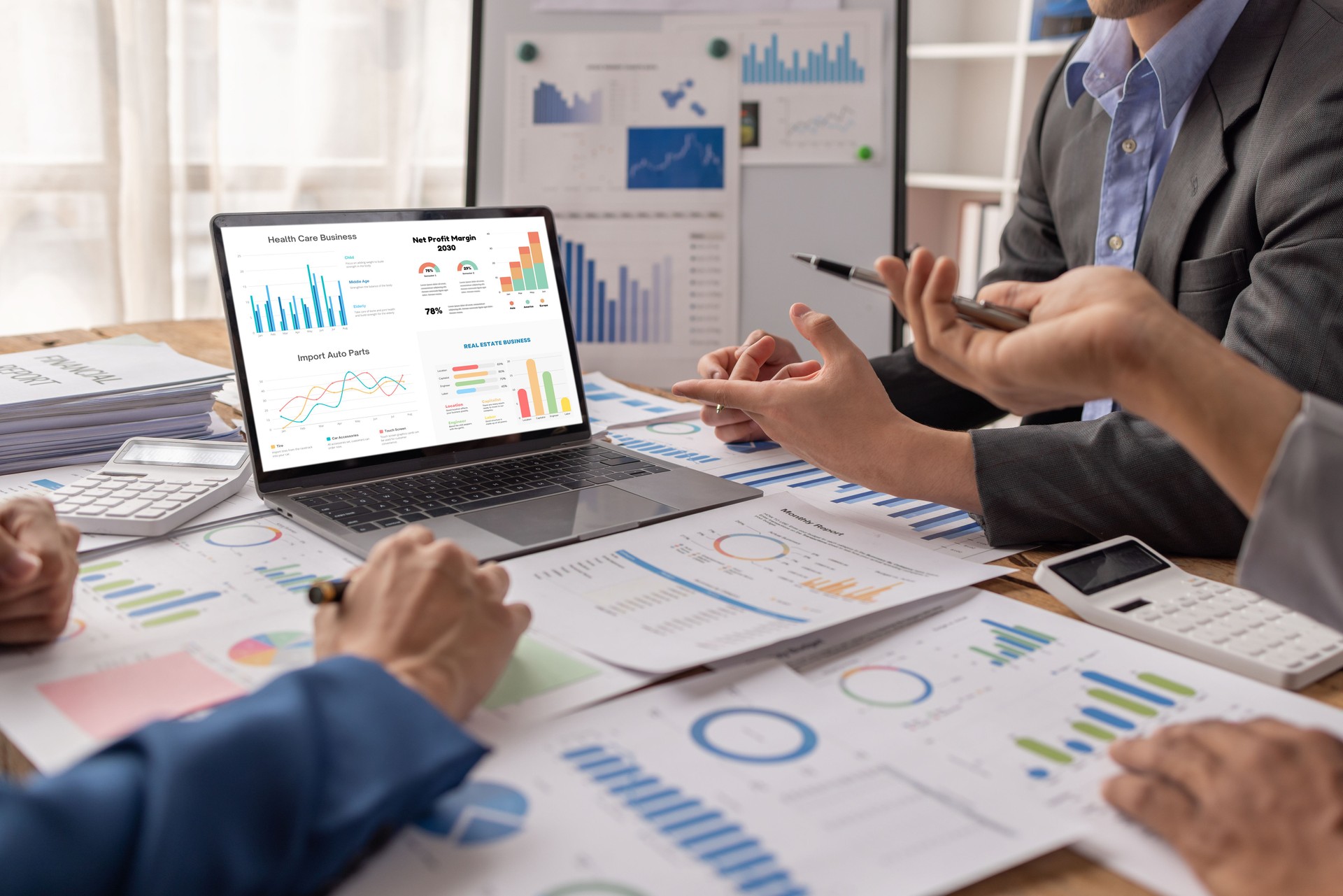 Groupe de gens d’affaires confiants pointent vers des graphiques et des tableaux pour analyser les données du marché, le bilan, le compte, le bénéfice net pour planifier de nouvelles stratégies de vente afin d’augmenter la capacité de production.